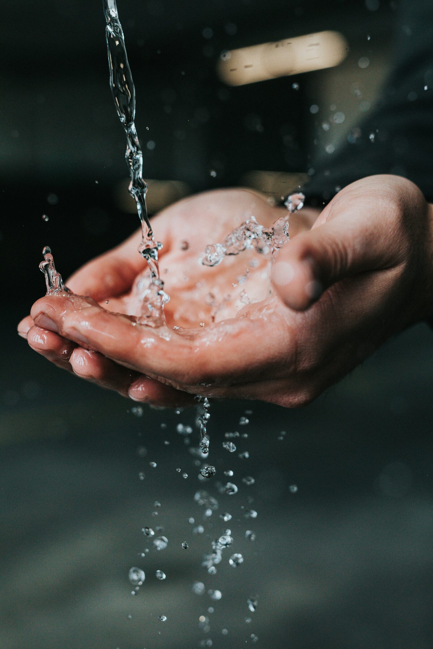Hands held beneath a stream of water
